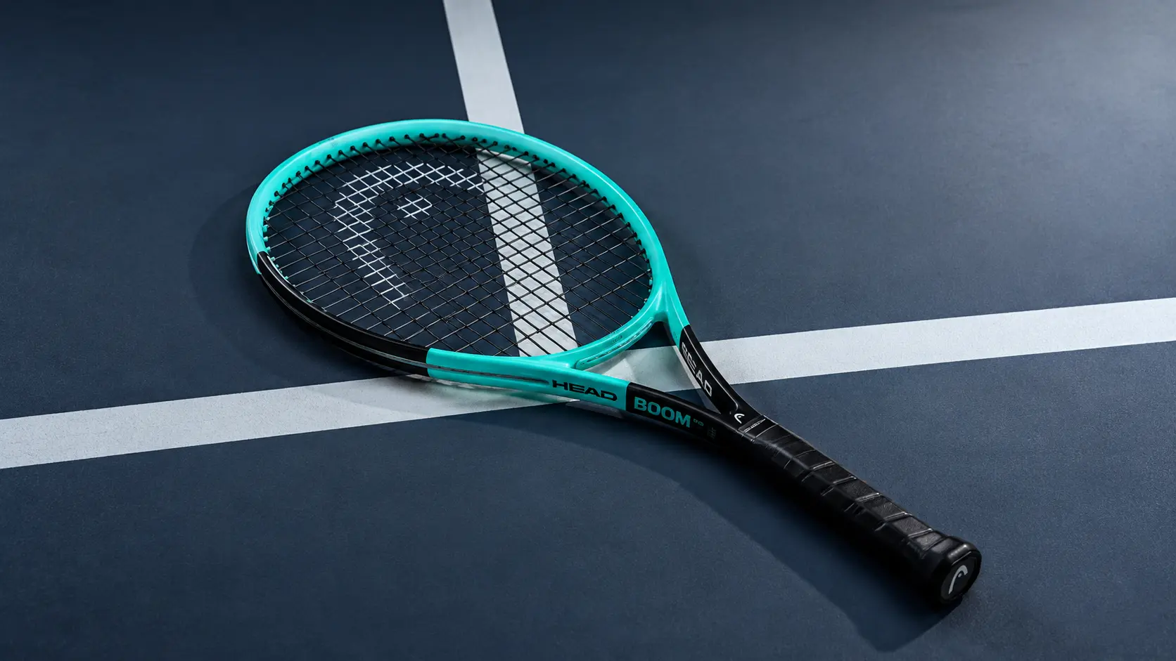 Raqueta Head Boom sobre una cancha de tenis, representando potencia fácil y comodidad moderna