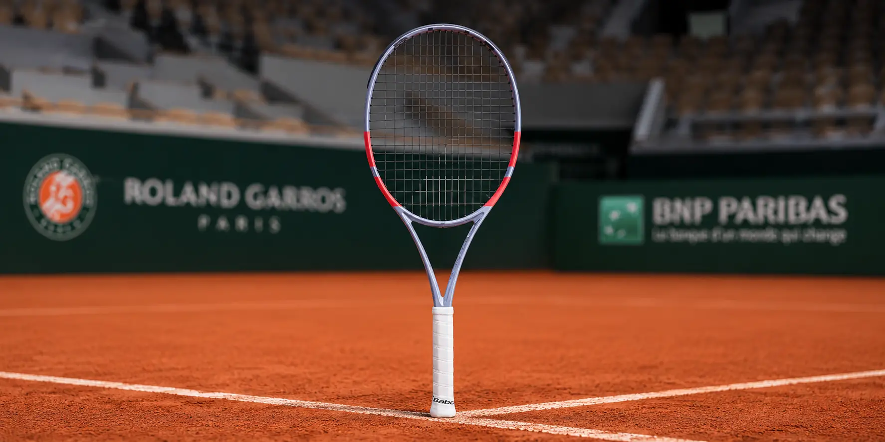 Raqueta Babolat Pure Strike sobre una cancha de tenis, representando la línea orientada a control ofensivo y precisión