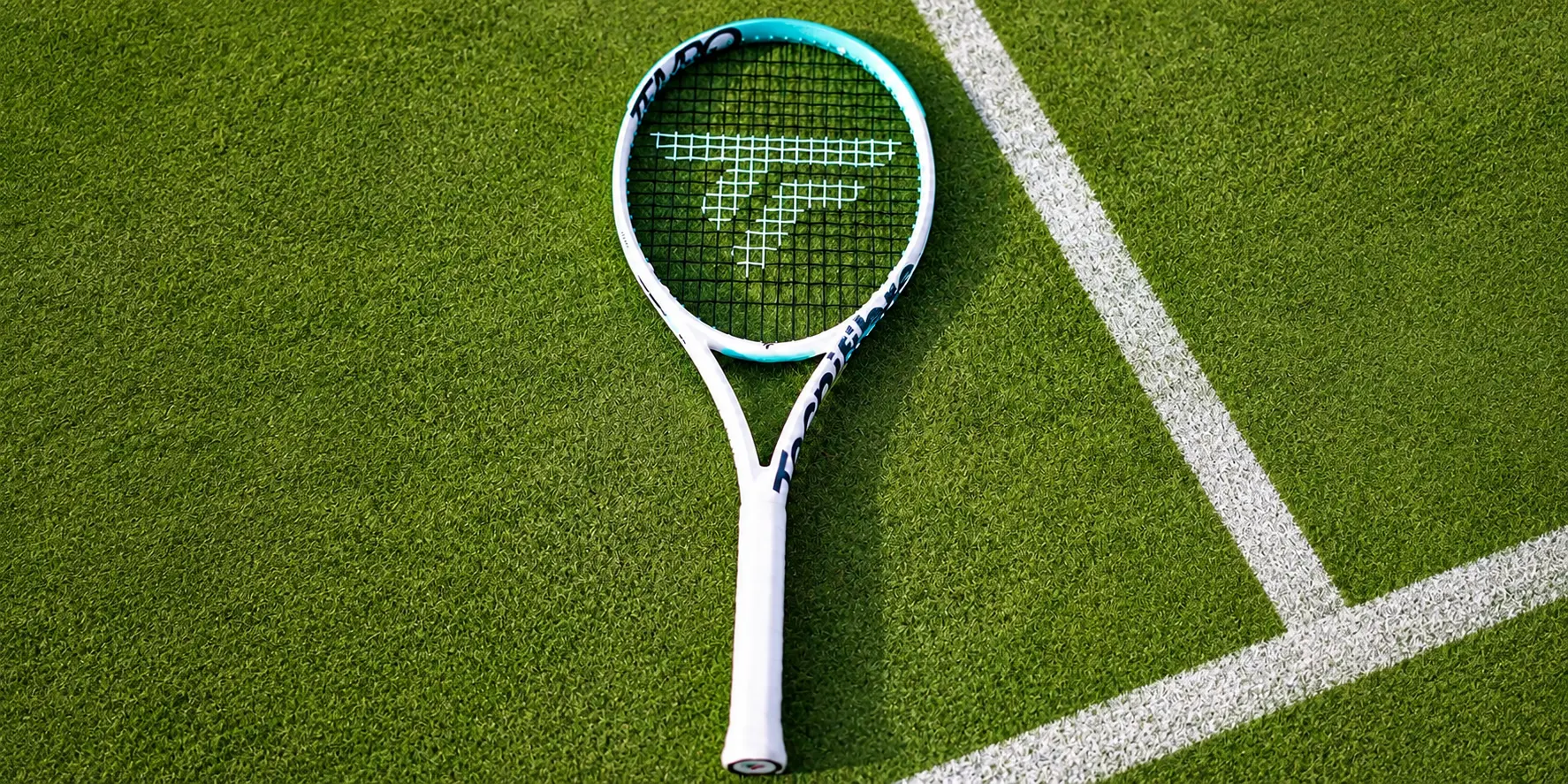 Tecnifibre Tempo racket on a grass court beside a white line